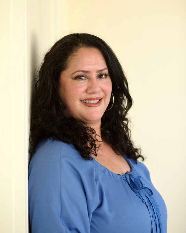 Lillian Medina Ochs, smiling, in a blue blouse